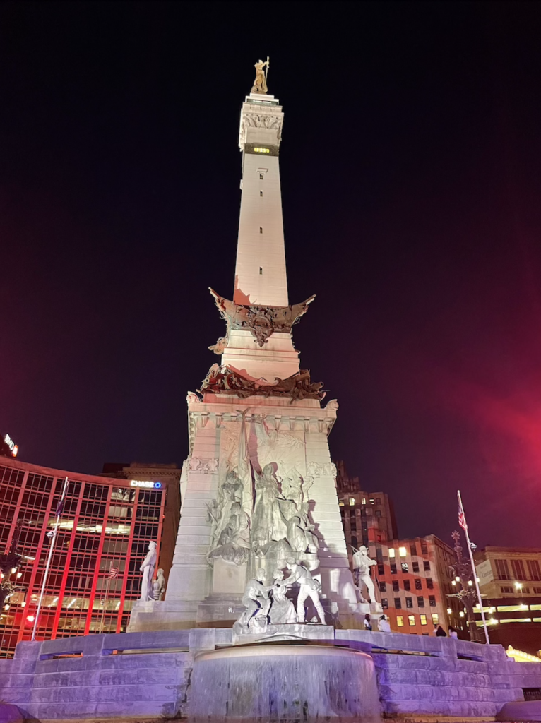 a tall statue with a group of people on it